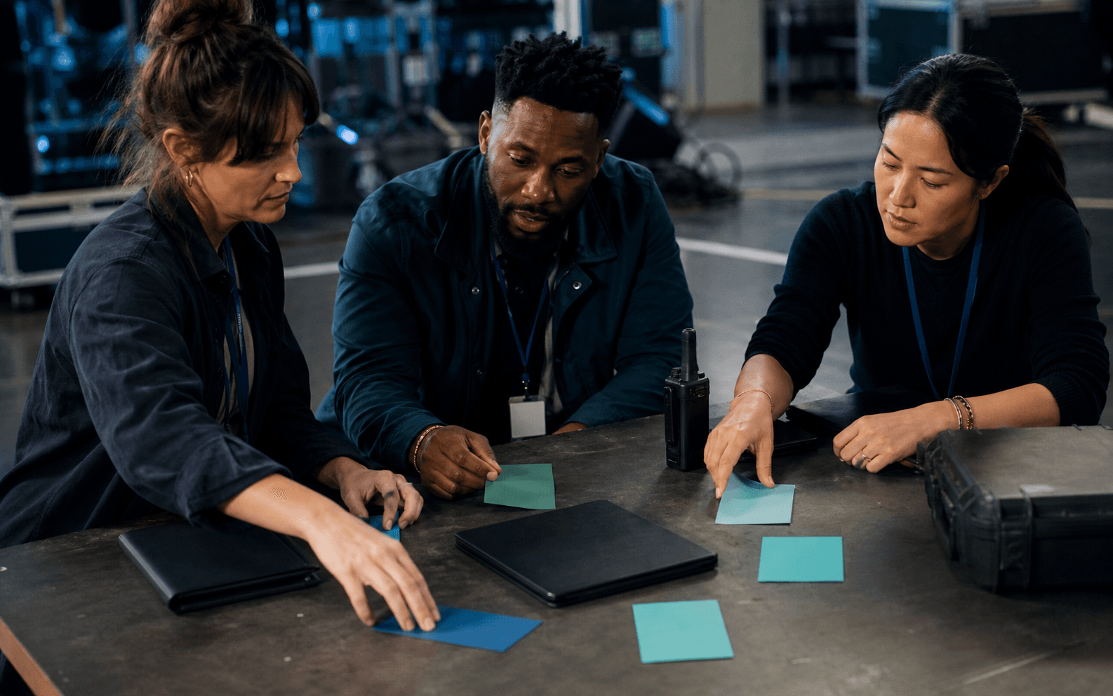 Three production leaders arranging blank action cards around an on-set worktable