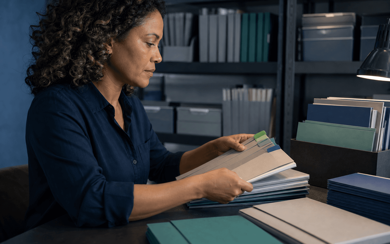 Onboarding administrator sorting blank color-tabbed packets in a records room